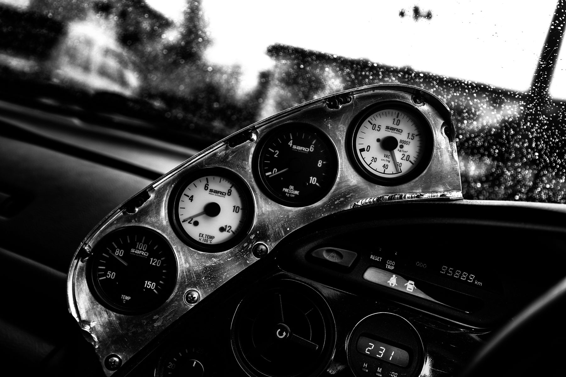 Black-and-white close-up of custom automotive performance gauges