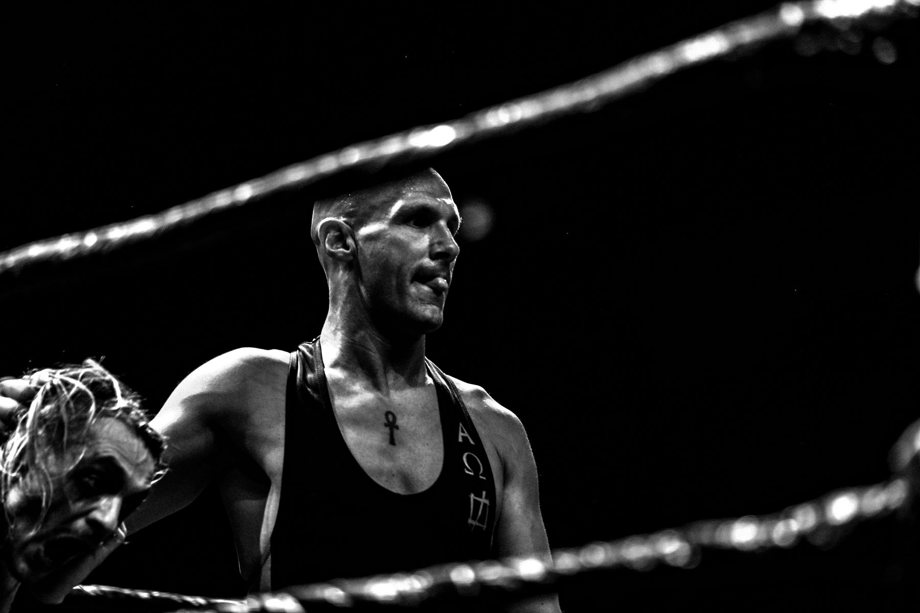 Black-and-white portrait of an athlete standing inside a wrestling ring